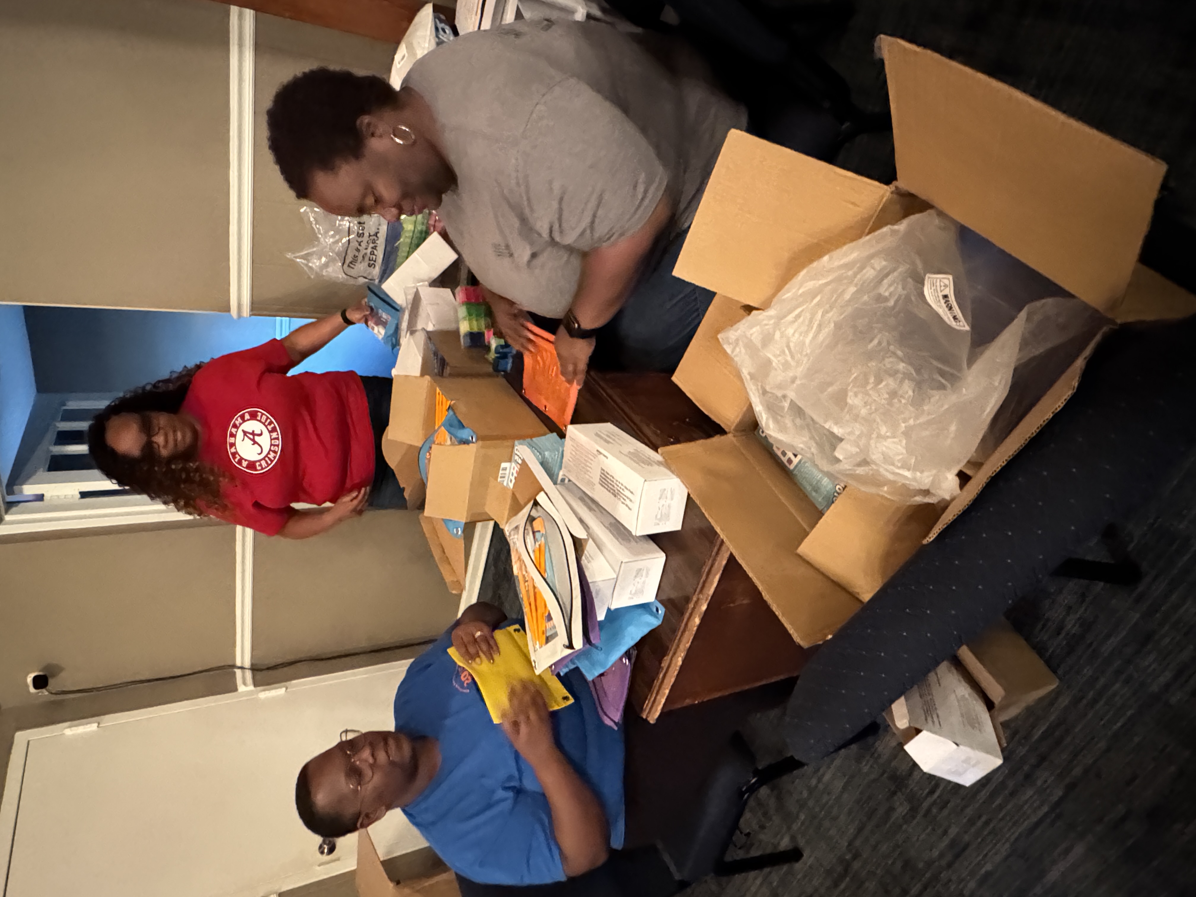 Volunteers organizing school supplies for the Back-to-School Community Youth Event.