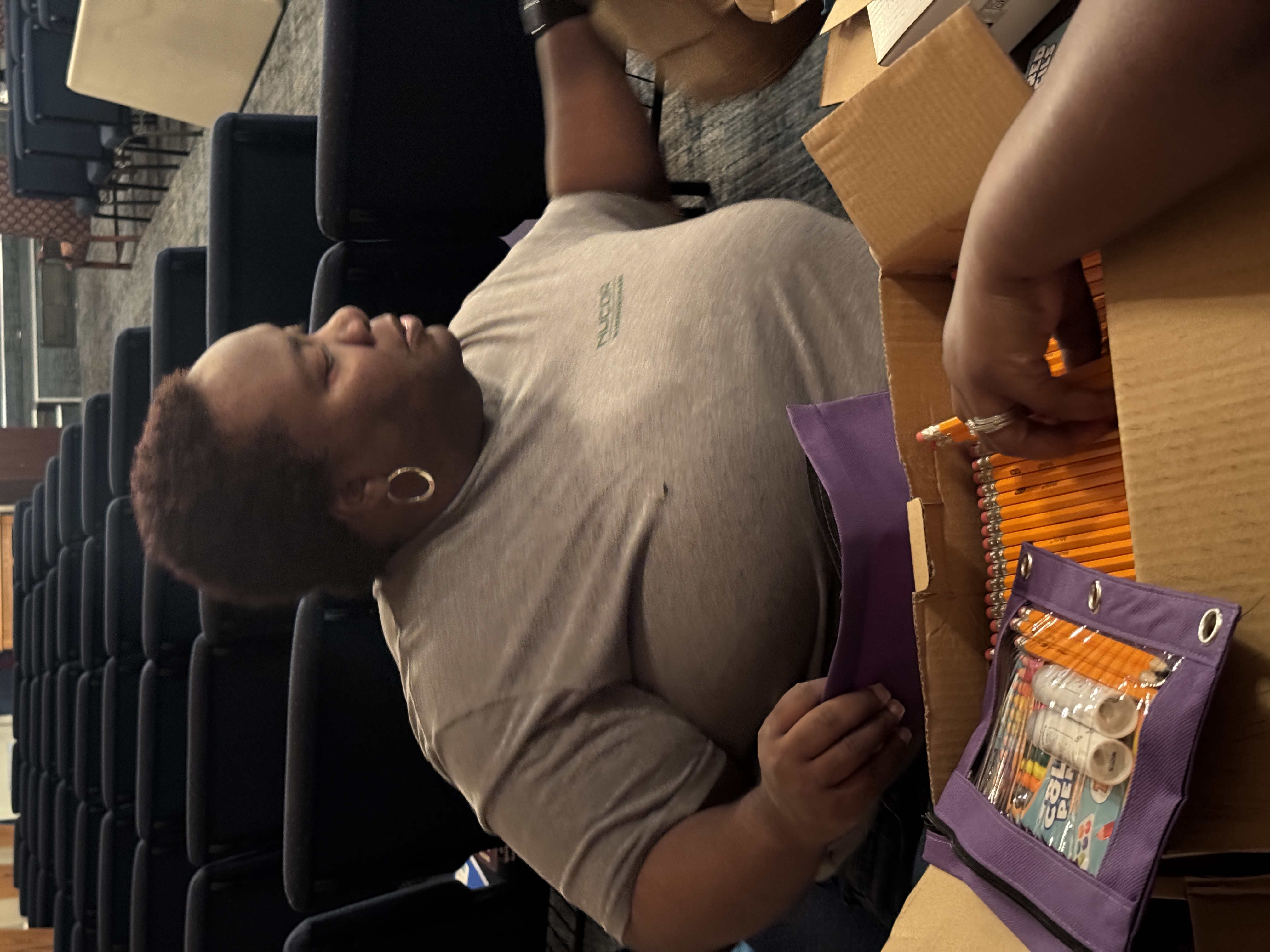Volunteer sorting school materials during event preparation.